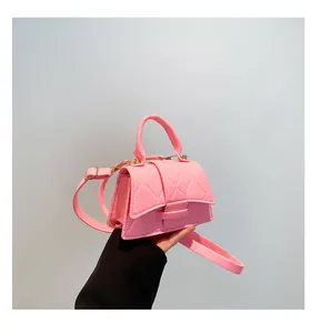 Detailed close-up of pink quilted mini handbag with fixed handle and gold-tone hardware