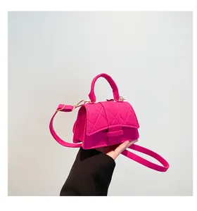 Detail of hot pink mini square handbag showing diamond quilted texture and top handle