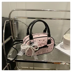 Detail of pink bowling bag with lace pearl bow and textured contrast handle