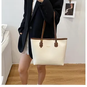Detail of cream leather tote bag with brown straps and KMDER & BAGS FASHION text