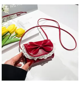 Top view of red mini crossbody bag with a large bow, lace trim, and tulip decorations