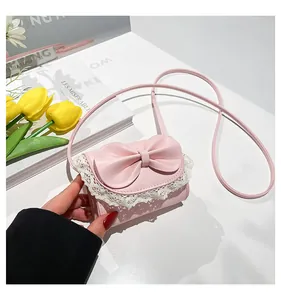 Detail of pink bow and white lace trim on a sweet style faux leather crossbody bag