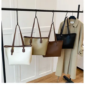 Minimalist tote bags in four neutral colors hanging on a rack for office commuters