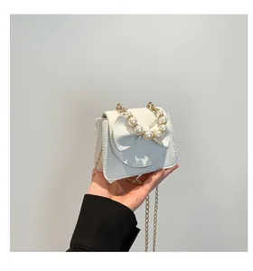 Close-up of white lychee leather mini bag with pearl handle and large bow detail