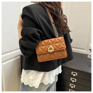 Détail du sac bandoulière matelassé marron avec boucle fer à cheval dorée et chaîne