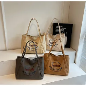 Detalle de bolsos tote de lona en cuatro colores con estampados de letras vintage