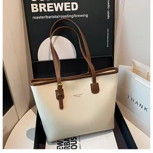 Close-up of premium cream leather tote bag with brown straps and KMDIER brand detail
