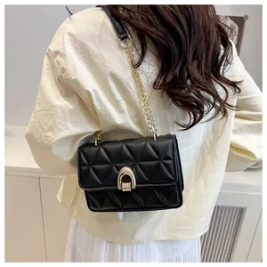 Détail d'un sac bandoulière matelassé noir avec chaîne dorée et fermoir fer à cheval