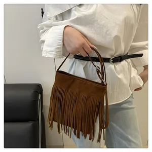 Détail du sac bandoulière en daim marron avec longues franges et boucle en métal réglable