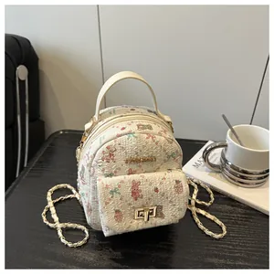 Detail of floral mini backpack with golden chain strap and cute cartoon bear pattern