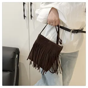Détail d'un sac à main en daim marron foncé avec de longues franges et bandoulière fine