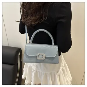 Detail of light blue patent leather bag with sparkling crystal G buckle and silver trim
