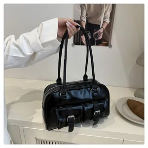 Détail d'un sac bowling en cuir verni noir rétro avec boucles argentées devant