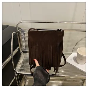 Détail d'un sac bandoulière en daim marron foncé avec franges de style vintage
