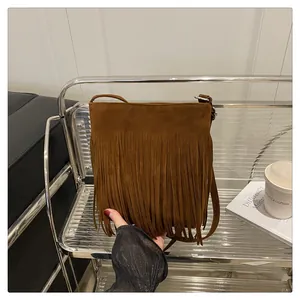 Détail d'un sac à main rétro en daim marron avec de longues franges et une bandoulière