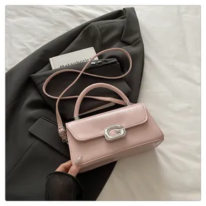 Close-up of pink leather handbag with luxury sparkling diamond-encrusted G metal buckle