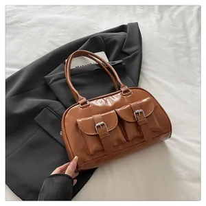 Détail du sac bowling rétro marron caramel avec poches cargo et boucles argentées