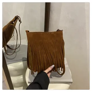 Détails de la sacoche en daim marron avec texture de franges et boucle métallique
