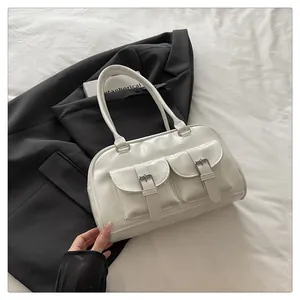 Détail du sac bowling blanc rétro avec poches frontales et boucles métalliques