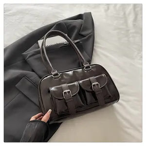 Gros plan d'un sac rétro en similicuir marron brillant avec poches à boucles en métal