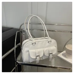 Détail du sac bowling blanc brillant avec boucles argentées sur chariot en verre