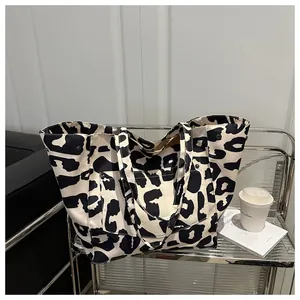 Detailed view of the cow print canvas tote bag with side metal buttons and wide straps
