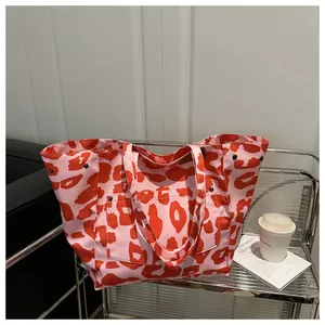 Gros plan du sac cabas imprimé léopard rose avec rivets et poche frontale fonctionnelle