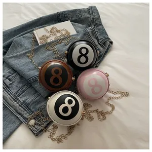 Detail view of colorful 8-ball shaped mini crossbody bags with golden chain straps