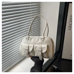 Détail du sac bowling blanc crème avec poches cargo rétro et texture en cuir mat