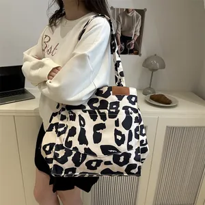 Grand sac cabas léopard avec poche frontale, porté à l'épaule pour un look chic