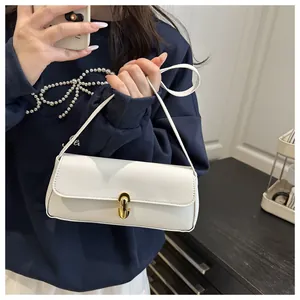 Detail view of white lychee pattern leather baguette bag with golden metal swivel lock