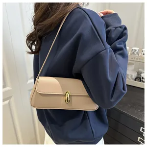 Detail of beige faux leather handbag featuring lychee grain texture and gold rotary lock