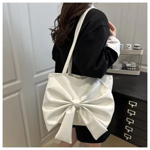 Dettaglio della grande borsa tote bianca con maxi fiocco e trama in pelle opaca premium
