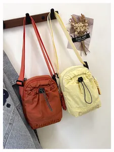 Detail of nylon crossbody mini bags with drawstring pocket and Duoning embroidery