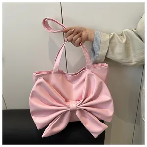 Dettaglio della borsa tote in pelle PU rosa con grande fiocco decorativo e doppi manici