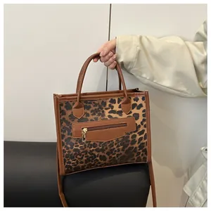 Detail of leopard print mini tote bag showing the gold zipper and vegan leather textures