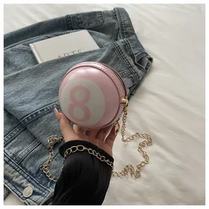 Detailed close-up of pink billiard 8-ball spherical crossbody bag with gold chain strap