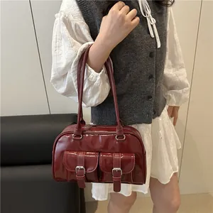 Sac bowling vintage en cuir rouge foncé brillant avec deux poignées et détails de boucles