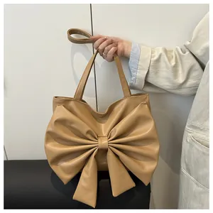 Dettaglio borsa tote beige con grande fiocco decorativo e morbida pelle sintetica pieghettata