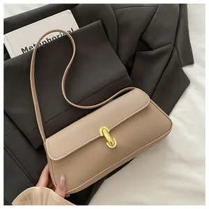 Close-up of beige lychee grain leather bag with elegant gold U-shaped metal buckle detail