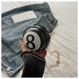 Detail shot of mini round billiard 8-ball crossbody bag with golden chain and PU leather