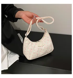 Detail of the hobo bag featuring corduroy texture and pink bow patterns with dual zippers