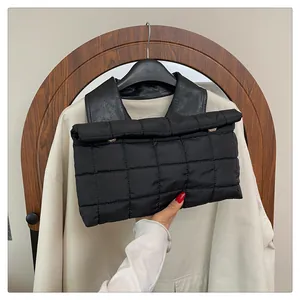 Detail of black quilted nylon envelope clutch with minimalist metallic buckle decoration