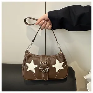 Detail of brown star handbag with white contrast stitching and silver star buckle