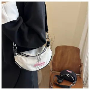Dettaglio borsa a mezzaluna PANYISSA in tela con logo ricamato rosa e ampia tracolla nera
