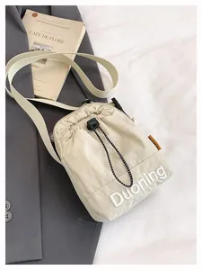 Detail of beige nylon crossbody bag with Duoning embroidery and adjustable strap