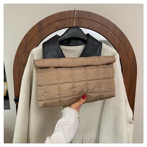 Detail of khaki quilted handbag showing the classic checkered pattern and gold magnetic buckle