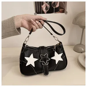 Macro shot of litchi texture leather and star-shaped metal buckle on a black shoulder bag