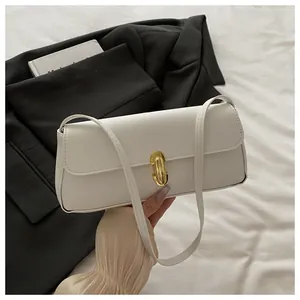 Close-up of off-white lychee textured leather baguette bag with golden U-shaped metal buckle