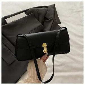 Detail of black lychee grain leather handbag with gold oval twist lock closure